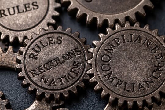 Metal gears engraved with rules regulations and compliance