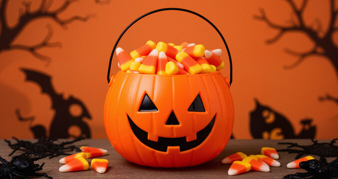Halloween celebration concept with candy corn and candy in jack o lantern bucket for trick and treat
