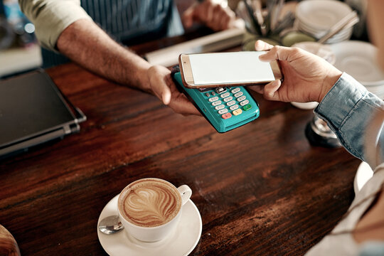 Customer, hands and phone with pos machine in coffee shop for wireless transaction or checkout. Top view, people or cashier with cashless tap or smartphone screen for banking app or payment in cafe