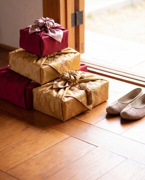 Korean holiday gift boxes wrapped in red and gold bojagi cloth by an entryway