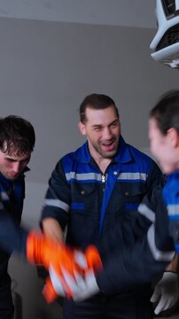 A professional group of automotive technicians works together inside a modern repair facility. The image represents teamwork, skilled labor, automotive maintenance, mechanical expertise, technical col