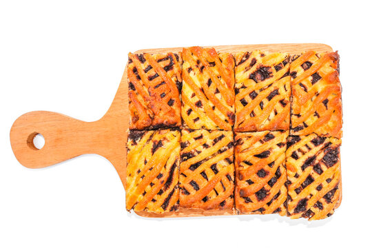 Delicious homemade banana and chocolate filled cake slices arranged on a wooden serving board isolated on a white background.