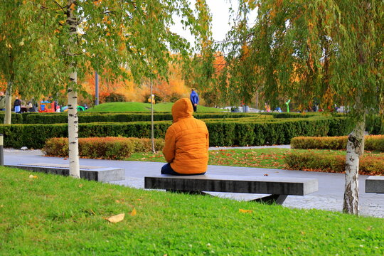 A man resting on a bench in an autumn park, autumn landscape in the city