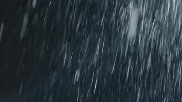 Dynamic streaks of heavy rain or snow against a dark background