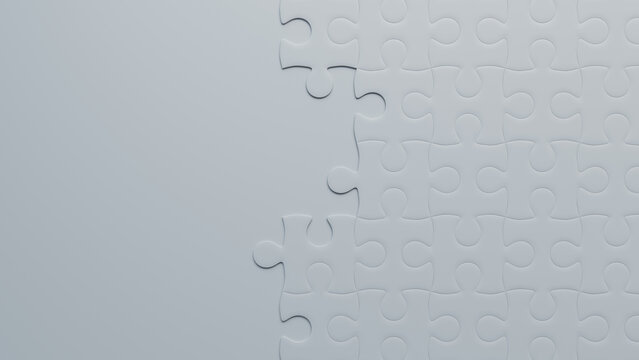 Challenge Unveiled: Glossy White Jigsaw Puzzle Awaiting Completion on Grey