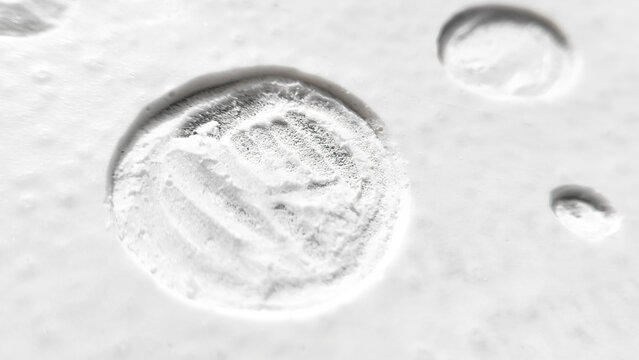 Embossed circular seal with numeric symbol stamped onto a textured white concrete or plaster background. Industrial signature design, vintage marking detail, clean architectural macro photography.