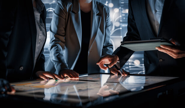 Business Team Collaborating on Interactive Touchscreen Table in Futuristic Office