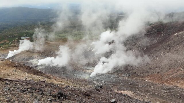 Active fumaroles emitting steam on a volcanic slope in Daisetsuzan, Hokkaido, Japan
