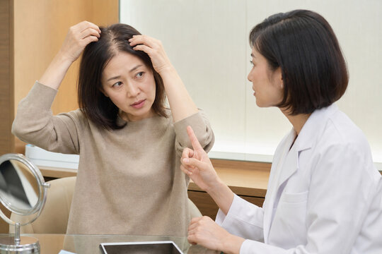 頭頂部の薄毛を医療従事者に相談する女性