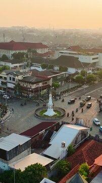 Golden hour aerial panorama of Tugu Jogja and surrounding urban streets