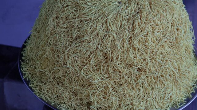 Traditional Indian crispy yellow sev snack stacked on market stall display