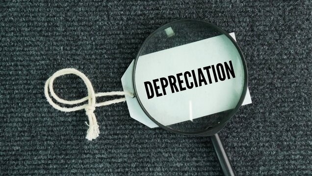 Tag the paper and magnifying glass with the word depreciation. accounting method that spreads the cost of a tangible asset over its useful life to match its decreasing value.