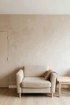 Single oat armchair against a muted clay lime washed wall in an empty room
