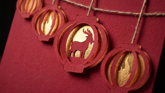 Beautiful red and gold paper lanterns featuring a goat silhouette for Chinese Lunar New Year celebrations and traditional zodiac festivities.