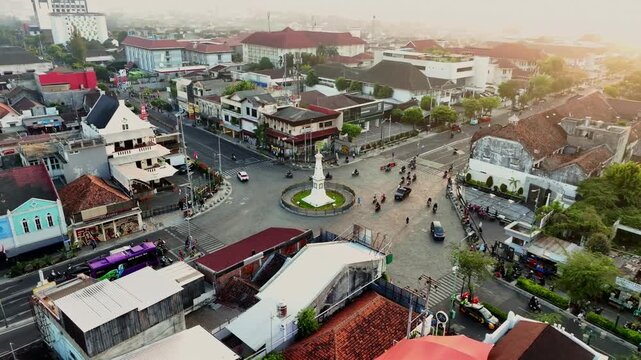 Tugu Jogja roundabout glowing in golden sunset above Yogyakarta city