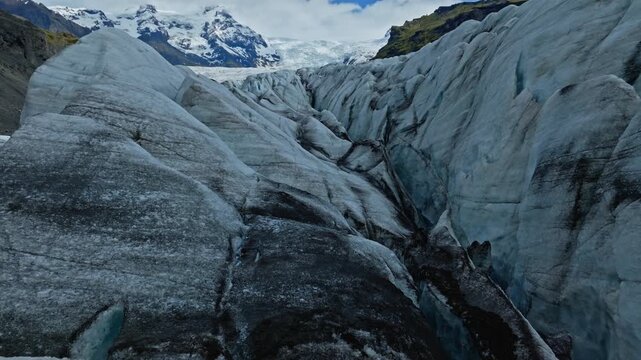Cinematic aerial flight above the spectacular glacier front of Fjalls&aacute;rl&oacute;n Glacier Lagoon in Iceland, revealing deep crevasses, blue glacial ice and the dramatic landscape of Vatnaj&ouml;kull.