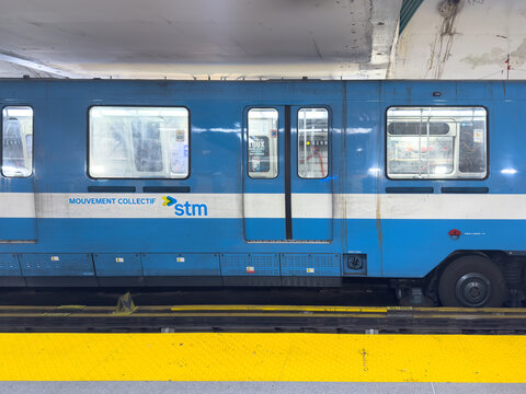 Montreal, Quebec, Canada. September 18, 2026. A side view of a blue STM subway train car stopped at a station platform.