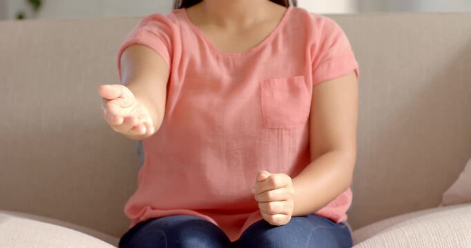 Close up of people talking to the camera, pointing forward, woman sitting on couch wearing casual pi
