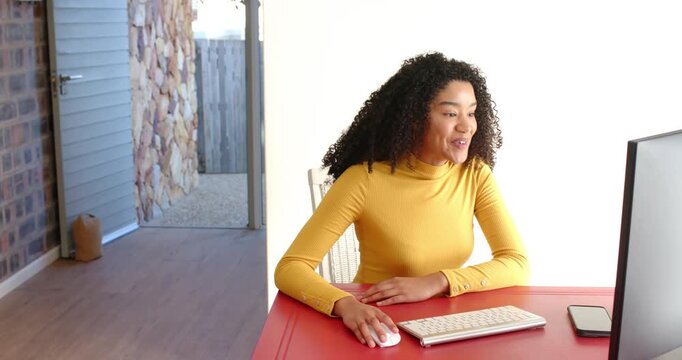 Lifestyle videos indoor of people doing activities at home, smiling girl in yellow sweater using com