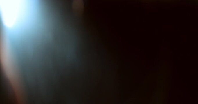 Slow motion of lens flare isolated on black background. Anamorphic lens. Cinematic glowing light overlay with optical streaks and rays for VFX compositing and transitions.