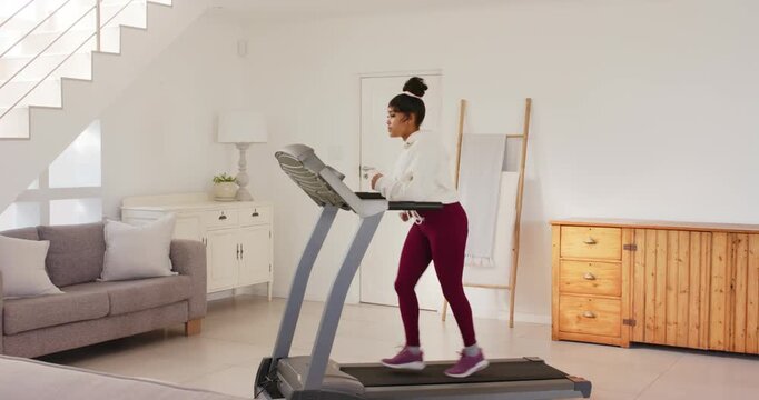 Lifestyle videos indoor of people doing activities at home, running on treadmill in living room, wom