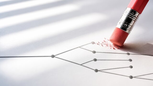 Pencil erasing a line on a grid paper graph, leaving behind smudges. The eraser works on an imperfect curve, changing its path. This image represents correcting errors or changing business strategies