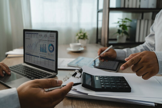Business team reviewing accounting financial reports tablet, calculator and printed reports at an office desk, showing financial planning, expense analysis and accounting workflow.
