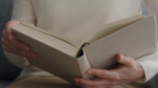 Hands opening a thick book with blank pages in close up