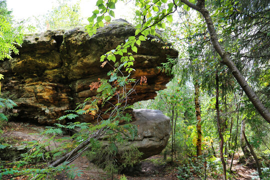 A rock hanging in the forest on a clear sunny day, Perm region. Nature sights of Russia.