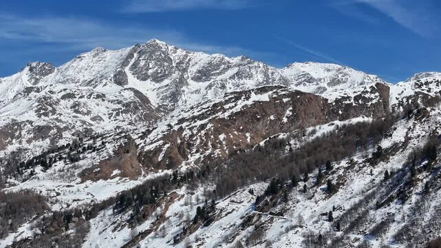 jagged summit ridge snow streaked granite swiss alps switzerland scree slope larch forest hillside graubunden engadin valley alpine wilderness winter drone aerial view