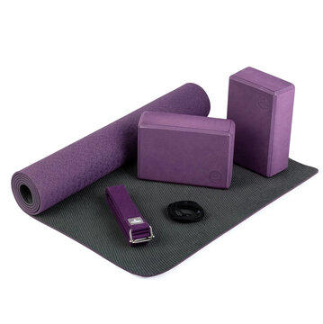 Purple yoga equipment set with rolled exercise mat foam blocks stretching strap and resistance loop band isolated on white background  