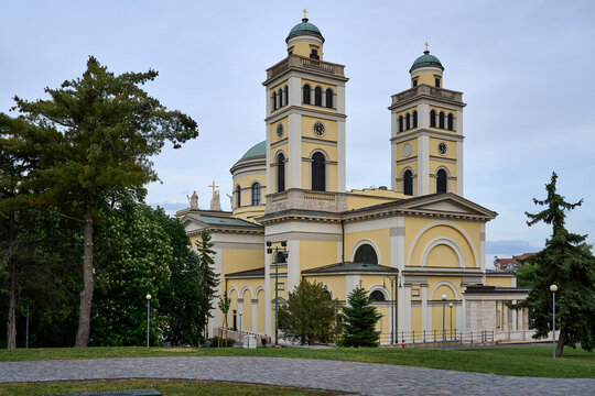 Neoclassical facade and towers of Eger Cathedral surrounded by trees and lawn in Eger, Hungary