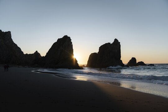 Marked rocks at Praia da Ursa beach at sunset, Ulgueira, Portugal
