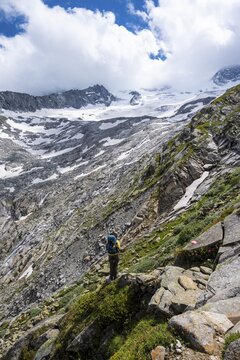 Hiker on marked hiking trail, descent from Sch&ouml;nbichler Horn to the Berliner H&uuml;tte, moraine landscape, Waxeggkees Glacier, Berliner H&ouml;henweg, Zillertal Alps, Zillertal, Tyrol, Austria