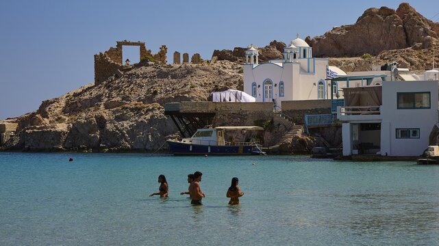 Agios Nikolaos church, blue dome church and ruins on a bay with floating people and a boat, Palio Ergostasio Kaolini, Old Kaolin loading station, ruins, Firopotamos, fishing village, north coast, beach, north coast, Milos, Cyclades, Greek Islands, Greece