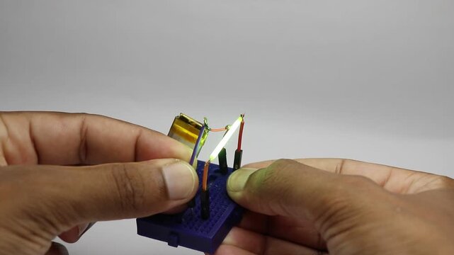 Retro style LED filament bulb being tested on a tiny breadboard connected to lithium polymer battery power