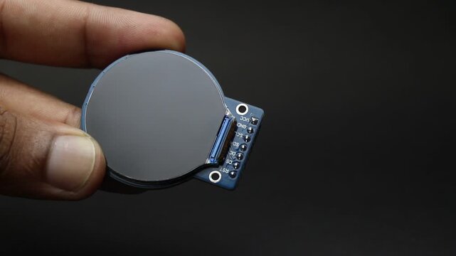 TFT LCD display module of round type held in the hand showing the details of the screen