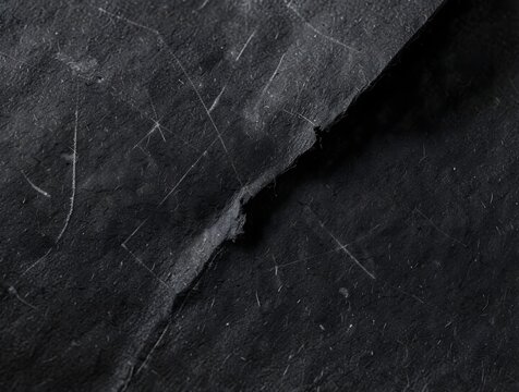 Black paper texture with torn edge and scratches