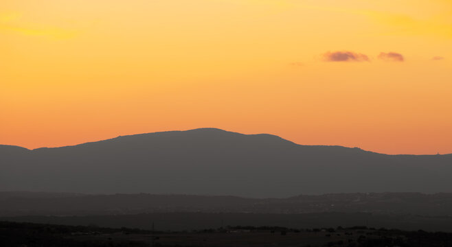 Atardecer en la Sierra de Guadarrama, en Madrid, Espa&ntilde;a. Cielo anaranjado con los &uacute;ltimos rayos de sol resaltando la silueta de las monta&ntilde;as situadas al norte de Madrid.