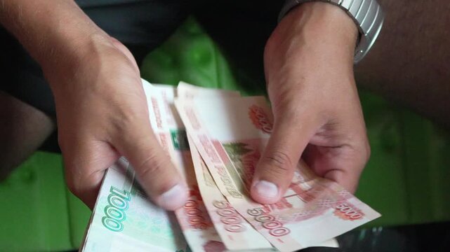 Money cash rubles, man counting Russian banknotes for financial transaction