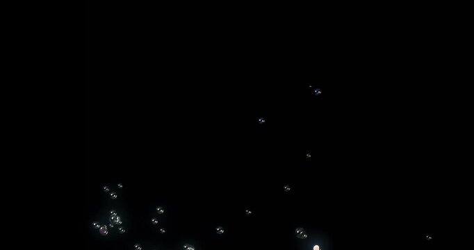 A mesmerizing display of delicate soap bubbles floating against a black background. This enchanting imagery is ideal for motion graphics and visual effects projects, adding elegance and creativity