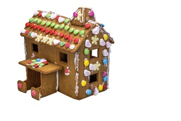 Obraz premium Close-up view of gingerbread house made by children for Christmas, isolated on white background. Sweden.