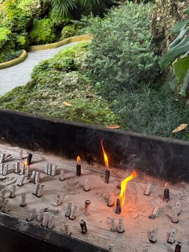 Incense burner with burning lucky number sticks in a sacred garden shrine