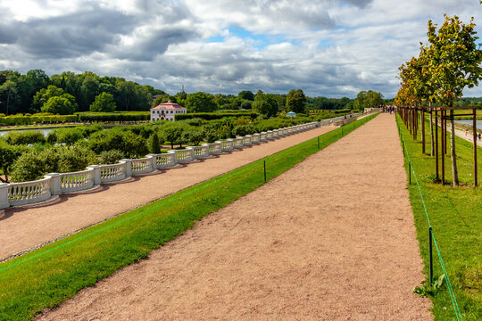 Scenic perspective view from historical Marly rampart walkway with balustrade. Classical terrace garden architecture with palace at Peterhof park near Saint Petersburg.