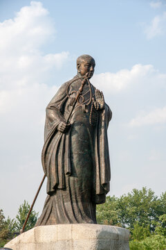 XI'AN, CHINA - JUNE 12, 2009: Bronze statue of the Buddhist monk Xuanzang in front of Da Ci'en Temple near the Giant Wild Goose Pagoda in Xi'an, Shaanxi, China. the Tang Dynasty.