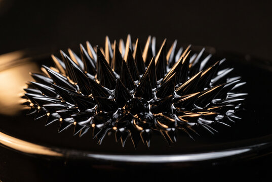 Black ferrofluid forming sharp glossy spikes, magnetic liquid macro