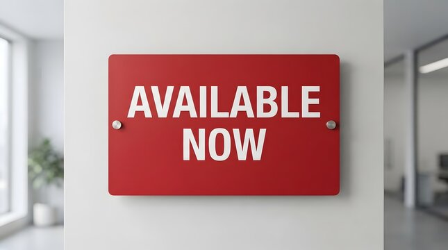 Modern Red Rectangular Wall Sign with Bold White Text Stating Available Now Mounted in a Clean Minimalist Office Environment for Business Vacancy or New Product Launch Announcement