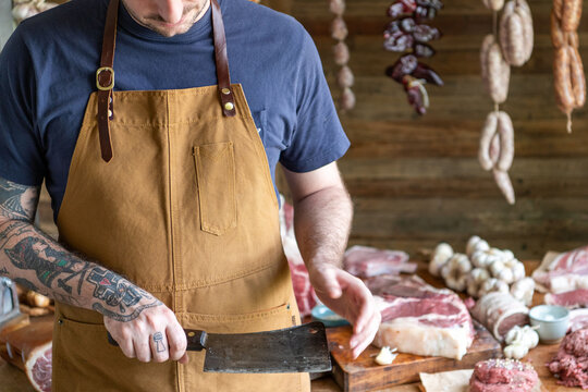 Butcher preparing fresh meat cuts.