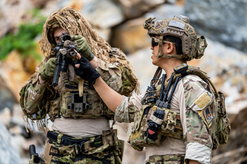 Fototapeta premium Soldiers conduct training in a rocky area while preparing weapons for an exercise