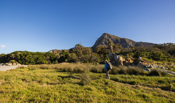 female hiker/photographer exploring Grotto Lagoon early morning, Hermanus, South Africa